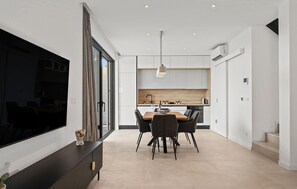 A modern kitchen with a dining area, a flat-screen TV, and a staircase. - Cozy home in Maslenica (Maslenica)