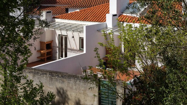 A residential area with a hilltop castle, terracotta-tiled roofs, and lush greenery. - Casa Filomena - Castle Walls (Óbidos)