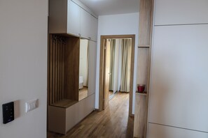 Ein Flur mit einem Holzschrank, einem Spiegel und einer Tür zu einem anderen Raum.