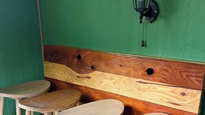 Een hoek met drie houten krukken, een groene muur en een houten hoofdeinde met een hangende zwarte lantaarn.