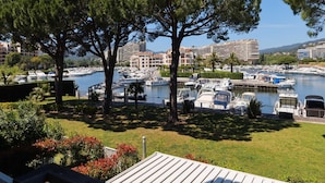A marina with boats, trees, and buildings in the background. - Marina Apartment With Terrace (Mandelieu-La-Napoule)