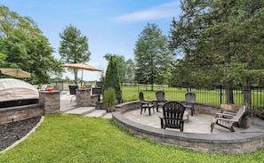 A backyard patio with a fire pit, outdoor seating, and a grill. - Hudson Retreat, Pool, Spa, Game Room, Gym (Gardiner)