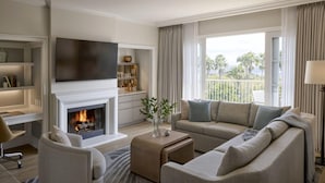 Ein modernes Wohnzimmer mit Kamin, einer Couch, einem Fernseher und einem Balkon mit Blick.