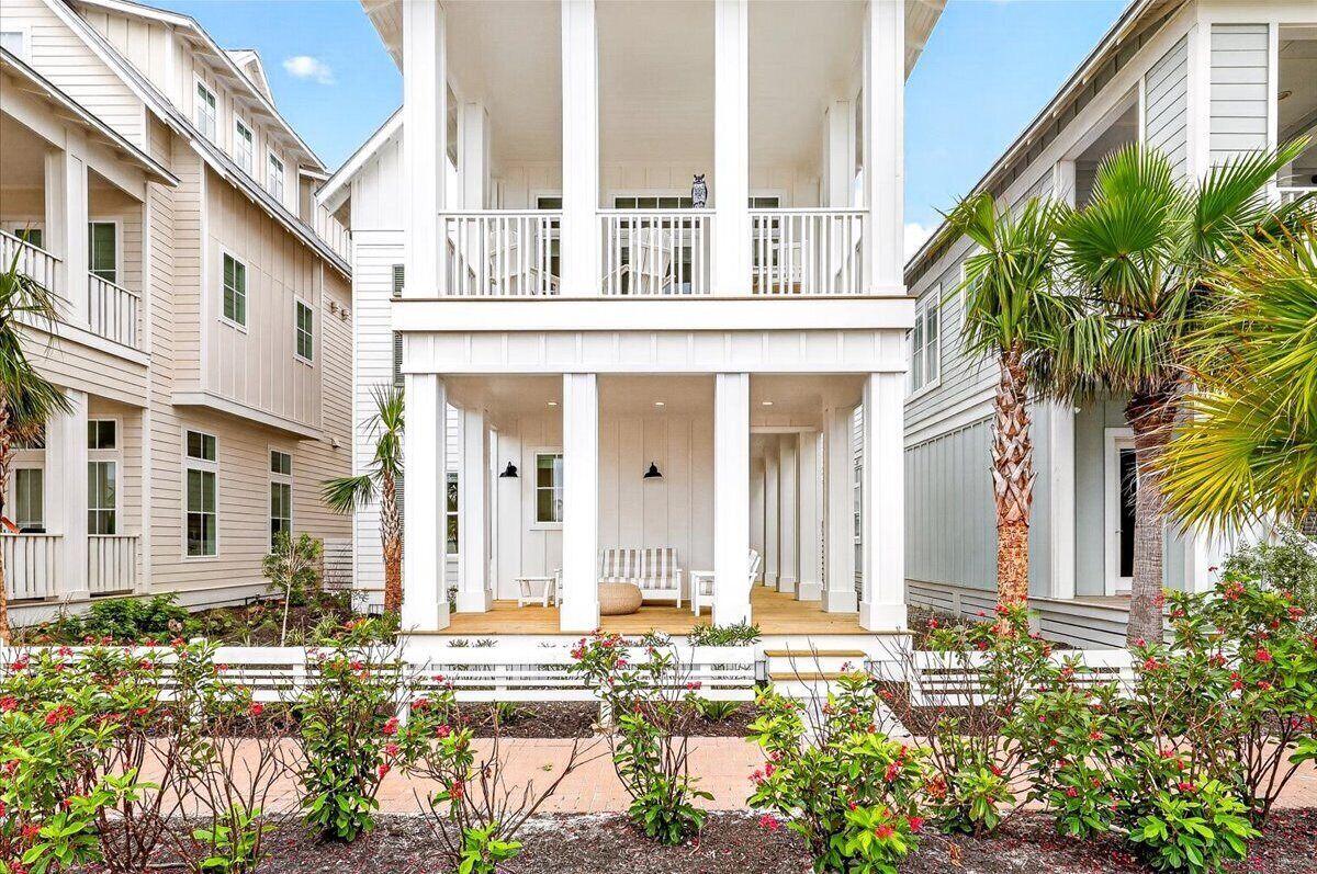 A two-story building with a central porch, columns, and a balcony.
