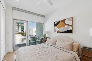 Ein Schlafzimmer mit einem Bett, einem Nachttisch, einer Lampe und einem Bild an der Wand.