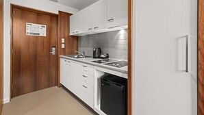 A modern kitchen with white cabinets, a black dishwasher, and a stainless steel sink.