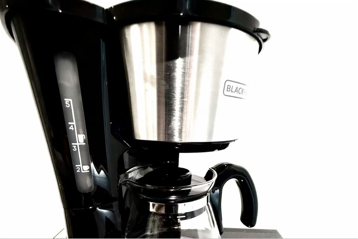 A black coffee maker with a stainless steel pot and a scale marked from 2 to 5.