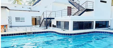Una piscina con un edificio moderno al fondo.