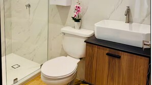 Un bagno moderno con toilette, doccia e lavabo.