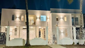 Un immeuble à deux étages doté de balcons, de garde-corps en fer forgé décoratifs et d’une façade bien éclairée.
