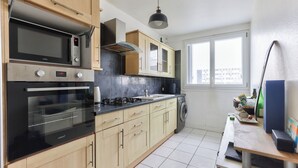 Eine Küche mit Mikrowelle, Backofen, Herd und Waschmaschine.