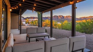A covered outdoor seating area with a view of mountains.