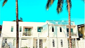 A two-story building with balconies, surrounded by palm trees. - Suite 09 • Private Suite • Boutique Mansion (Guayaquil)