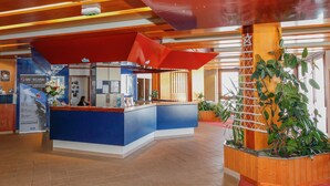 A reception area with a blue counter, a red awning, and a wooden planter with green plants. - Studio Cosy + Accès Direct aux Pistes! (Saint-Martin-de-Belleville)