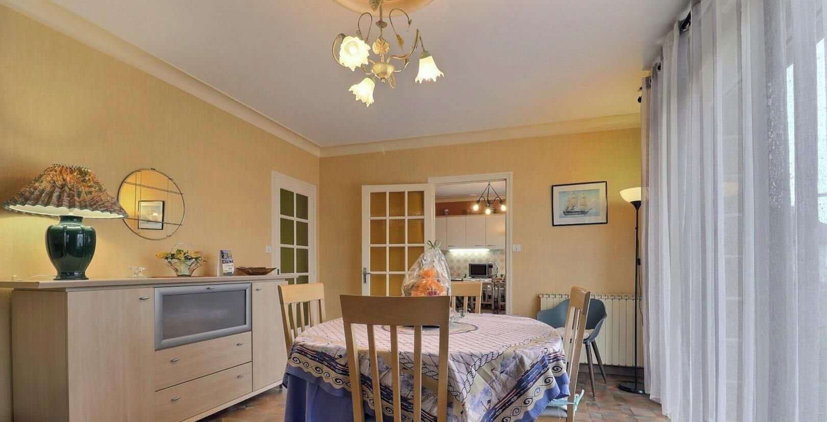 A room with a bed, a desk, a chair, a lamp, and a television.