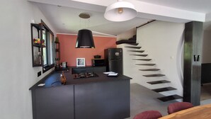 A modern kitchen with a central island, a black pendant light, and a stainless steel refrigerator. - Luxury house in the heart of the Luberon (Apt)