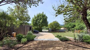 A gravel driveway leading to a wooden shed, surrounded by greenery and trees. - Luxury house in the heart of the Luberon (Apt)