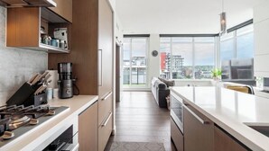 Cocina moderna con vistas a la ciudad, un comedor y una sala de estar con sofá.