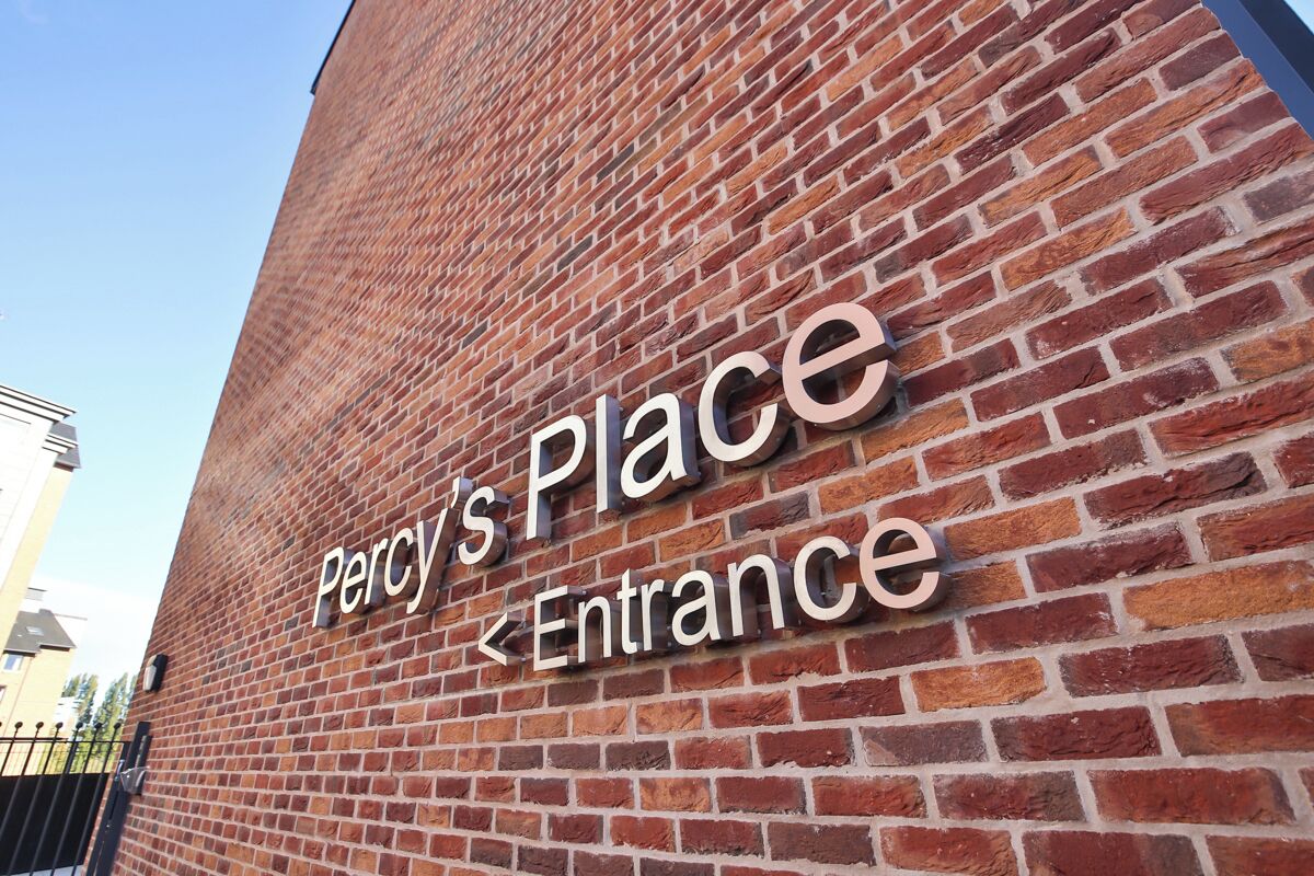A brick wall with signage indicating 'Percy's Place <Entrance>'.