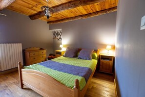 Ein Schlafzimmer mit einem Holzbett, zwei Nachttischen mit Lampen, einer Kommode und einer Heizung.