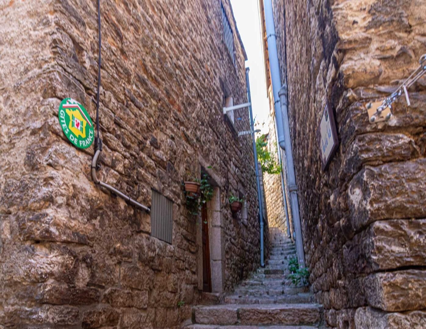 A narrow stone alleyway with a staircase leading up.