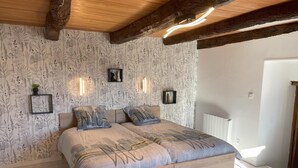 Ein Schlafzimmer mit einem hölzernen Bett, floralem Wandpapier und Wandleuchten.