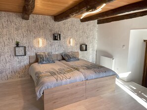 Ein Schlafzimmer mit einem hölzernen Bett, floralem Wandpapier und Wandleuchten.