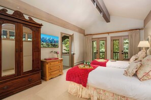 A bedroom with a large wooden wardrobe, a wooden dresser, a bed with floral bedding, and a painting of mountains. - Abode at Guyer Hot Springs, walk to lift, hot tub (Ketchum)