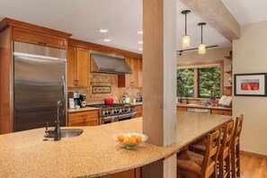 A kitchen with a stainless steel refrigerator, a gas stove, and a granite countertop. - Abode at Guyer Hot Springs, ski slope views, walk to lift, hot tub (Ketchum)