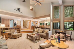 A spacious living area with a high ceiling, a kitchen in the background, and a dining area with a table and chairs. - Abode at Guyer Hot Springs, ski slope views, walk to lift, hot tub (Ketchum)