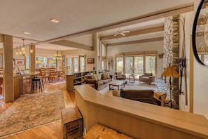 A spacious living area with a kitchen, dining area, and a stone accent wall.