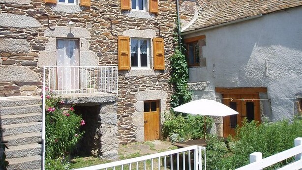 A stone building with wooden shutters, a balcony, and a white umbrella. - Chez Baptiste - SAINT-PIERRE-DE-NOGARET (SAINT-PIERRE-DE-NOGARET)