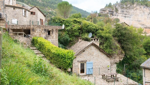 A stone building with a small porch and a satellite dish. - Gîtes de France 3/5 pers in Saint-Chély-du-Tarn (SAINT-CHELY-DU-TARN)