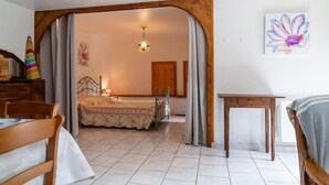 Ein Schlafzimmer mit einem Bett, einem Holztisch, einem Stuhl und einem Bild an der Wand.