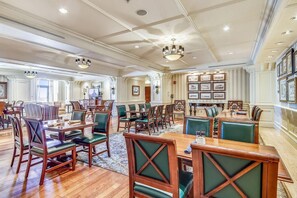 A spacious dining area with multiple tables and chairs, a chandelier, and framed pictures on the walls. - Emerald Grande W522- Harbor Breeze (Destin)