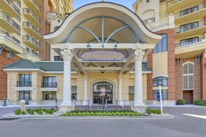 Ein Hotel Eingang mit einem Schild, das 'Emerald Grande' zeigt, mit klassischer Architektur, Säulen und einem gewölbten Dach.