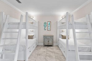 Ein Zimmer mit Etagenbetten, einem kleinen Schrank und einer Wanddekoration.