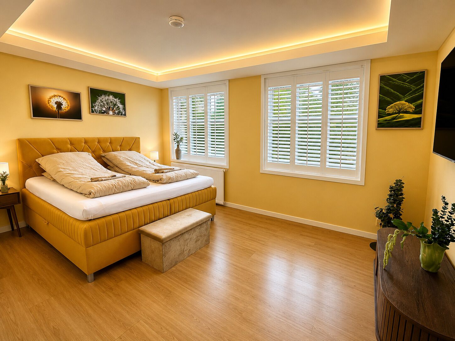 A bedroom with a bed, bedside tables, a bench, and a window with blinds.