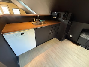 A compact kitchen with a dishwasher, a sink, and a built-in oven.