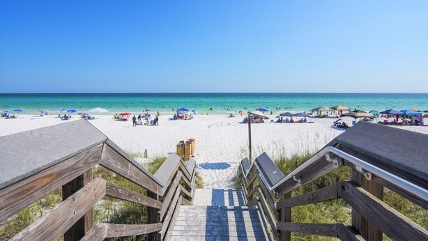 A wooden staircase leading to a beach with umbrellas and people. - Driftwood Townhomes #1- Beachwaves (Miramar Beach)