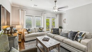 A living room with a sofa set, a coffee table, a lamp, and a ceiling fan. - Driftwood Townhomes #1- Beachwaves (Miramar Beach)