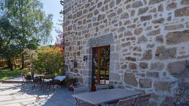 A stone building with a patio area featuring outdoor seating and a table. - Gîte La Narce - TERMES (TERMES)