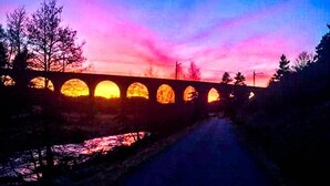 Eine Brücke mit mehreren Bögen im Abendlicht.