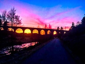 Un puente con múltiples arcos al atardecer.