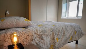 Ein Schlafzimmer mit einem Bett, einer Nachttischlampe und einem Fenster.