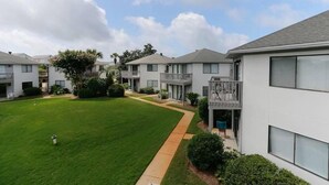 A residential building with a well-maintained lawn, a pathway, and a balcony. - Crystal Village II 8B- Vitamin Sea (Miramar Beach)