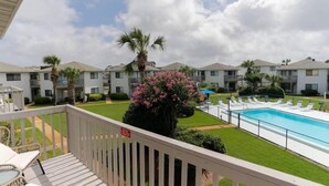 A residential building with a swimming pool, a fenced deck, and a well-maintained lawn. - Crystal Village II 8B- Vitamin Sea (Miramar Beach)