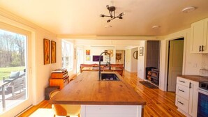 Una cocina espaciosa con una isla central, piso de madera y vistas al exterior.