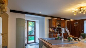 Une cuisine dotée d’un grand îlot central, de meubles en bois et offrant une vue sur l’extérieur.