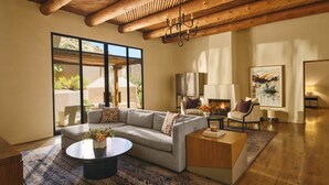 A modern living room with a sectional sofa, a round coffee table, a fireplace, and a large window with a view. - 2-bedroom Resort in soothing Scottsdale with AC and fitness room (Scottsdale)